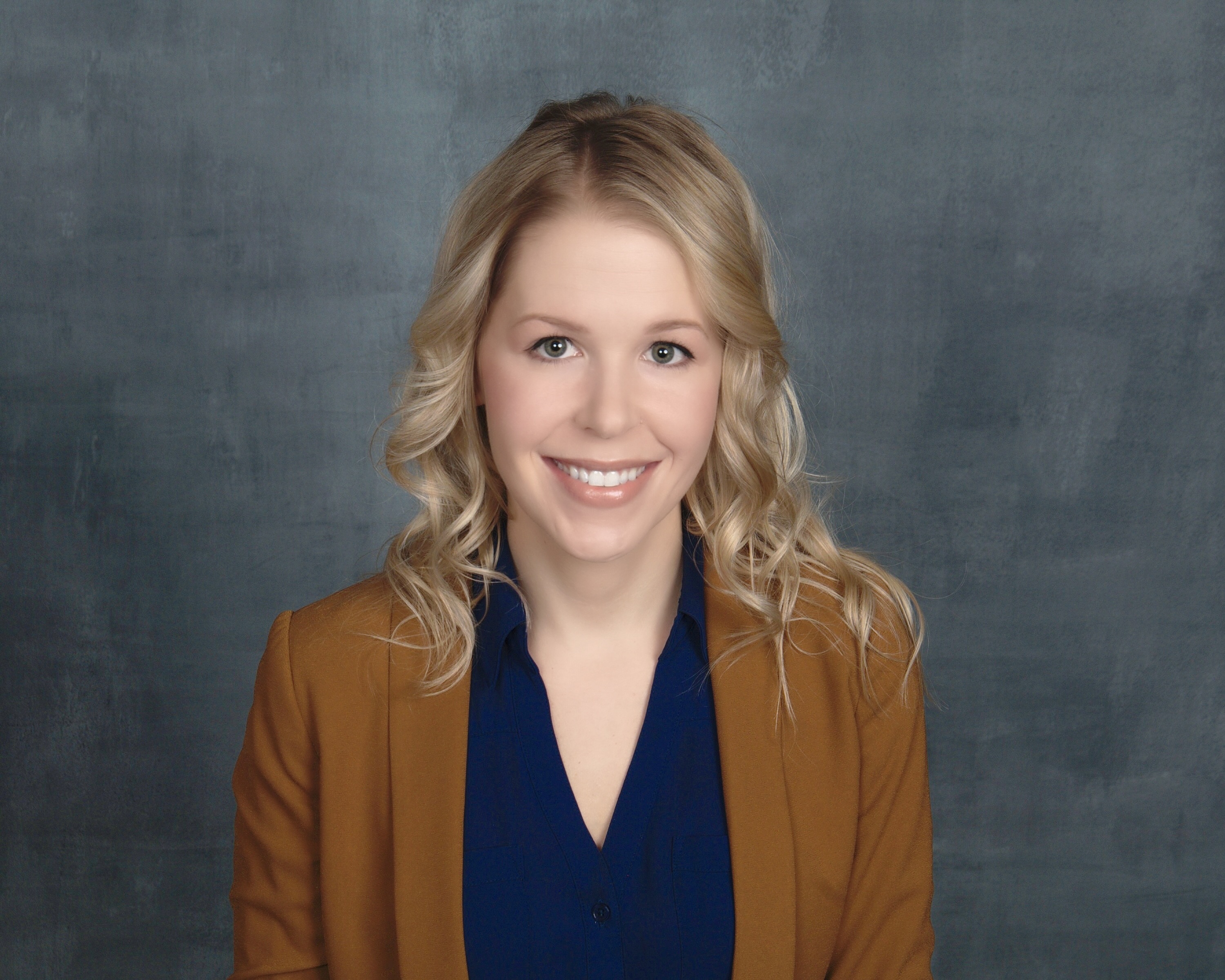 Illiana Falkenstern, speech-language pathologist, smiling in a brown blazer